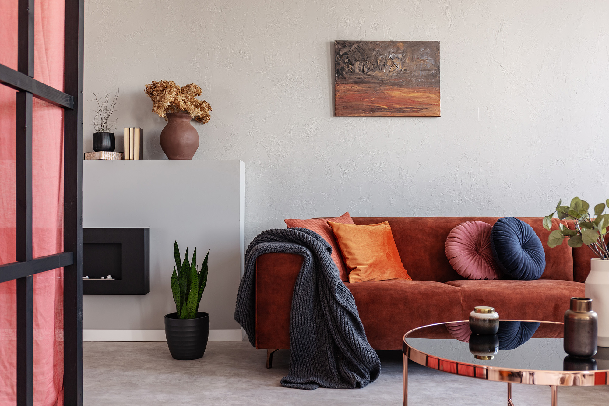Stylish living room interior with trendy sofa with pillows, real ph