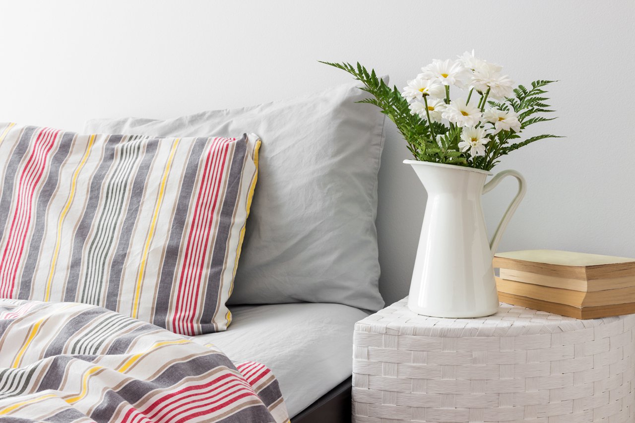 White-flowers-and-books-on-a-bedside-table-